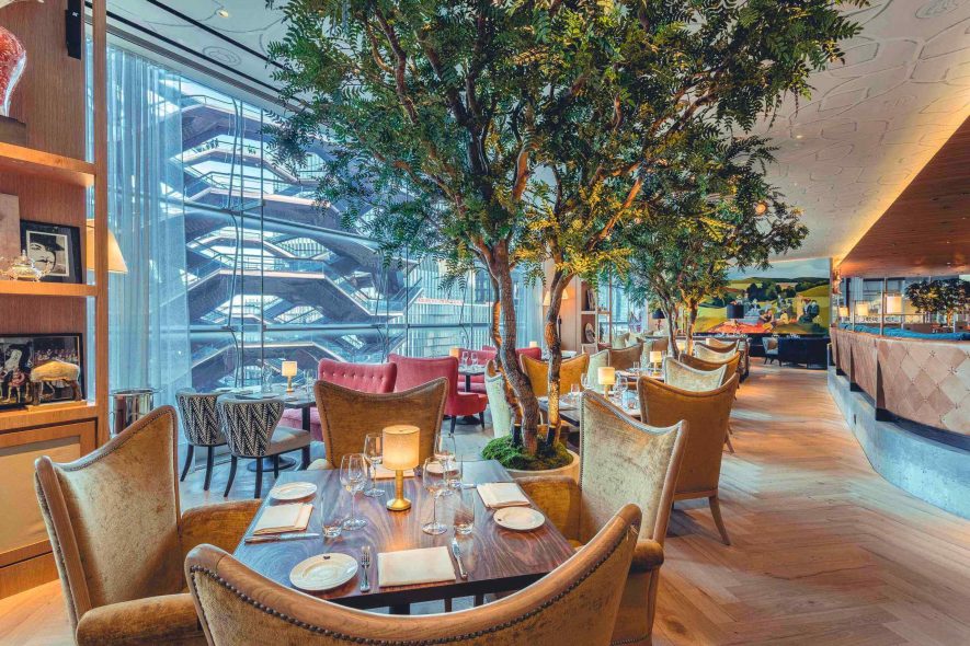 Daytime view of Artificial indoor Acacia trees inside the Queensyard Restaurant in New York