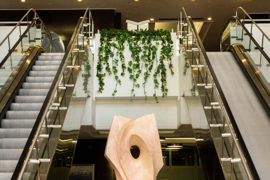 Replica ivy hangs between the escalator landings above the sculpture at Datran Business Center