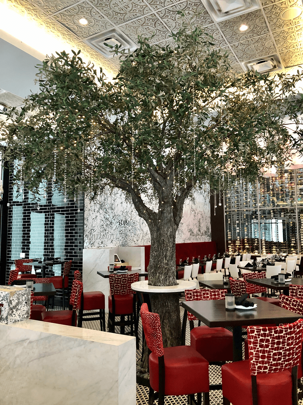 Custom fabricated Olive Tree functions as column concealment wrap in Florida Restaurant